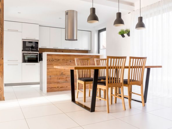 A kitchen with wooden chairs and table in it