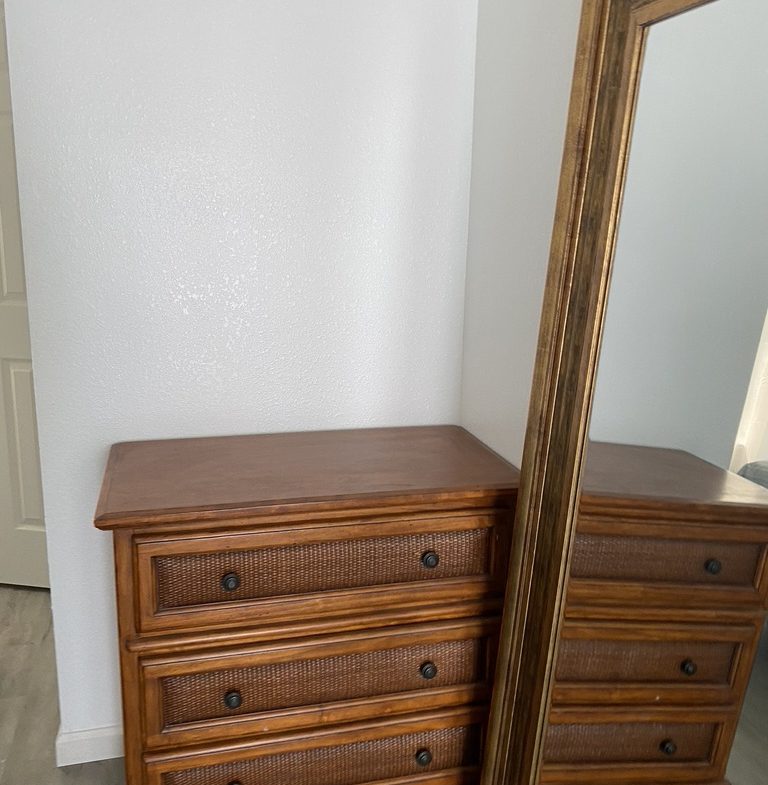 A dresser and mirror in the corner of a room.