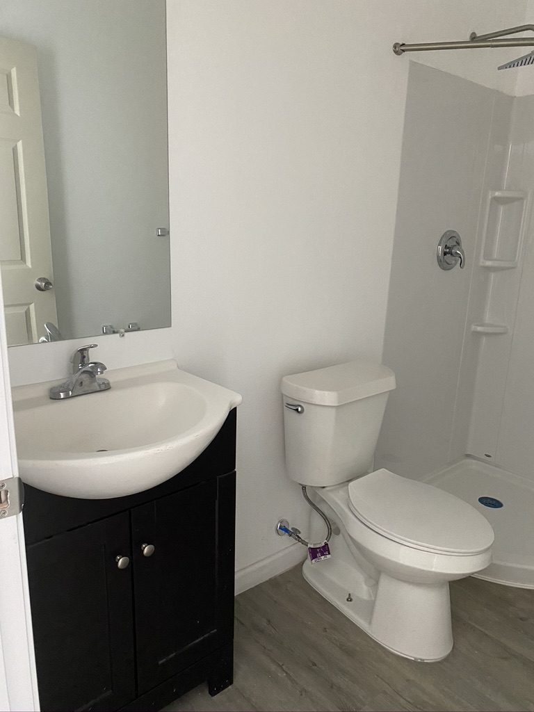 A bathroom with a sink, toilet and shower.