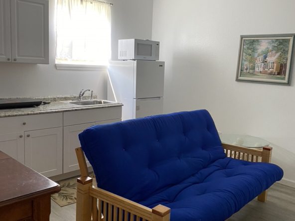 A blue futon in the living room of a small apartment.