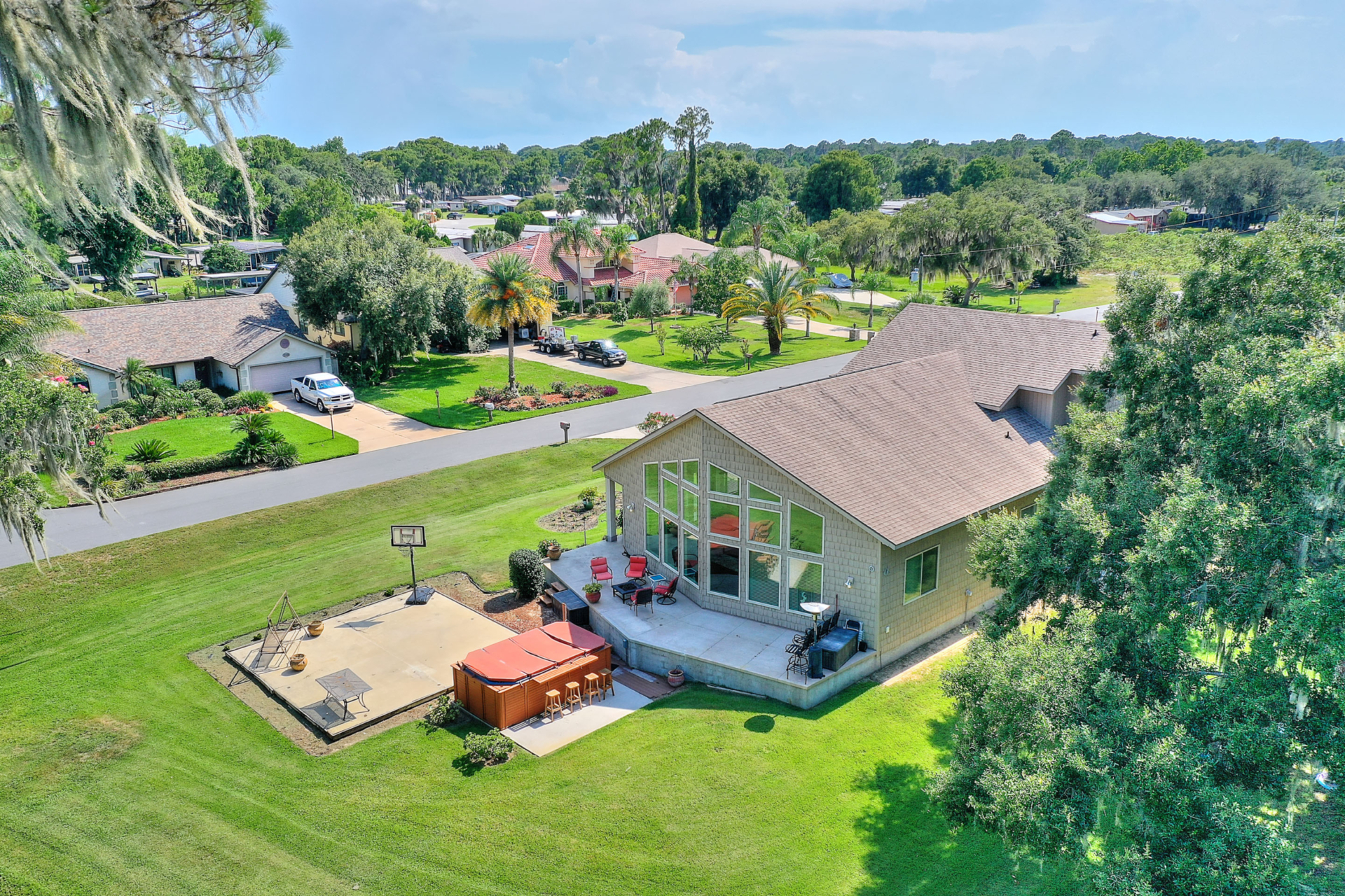 A large house with a deck and patio in the middle of it.