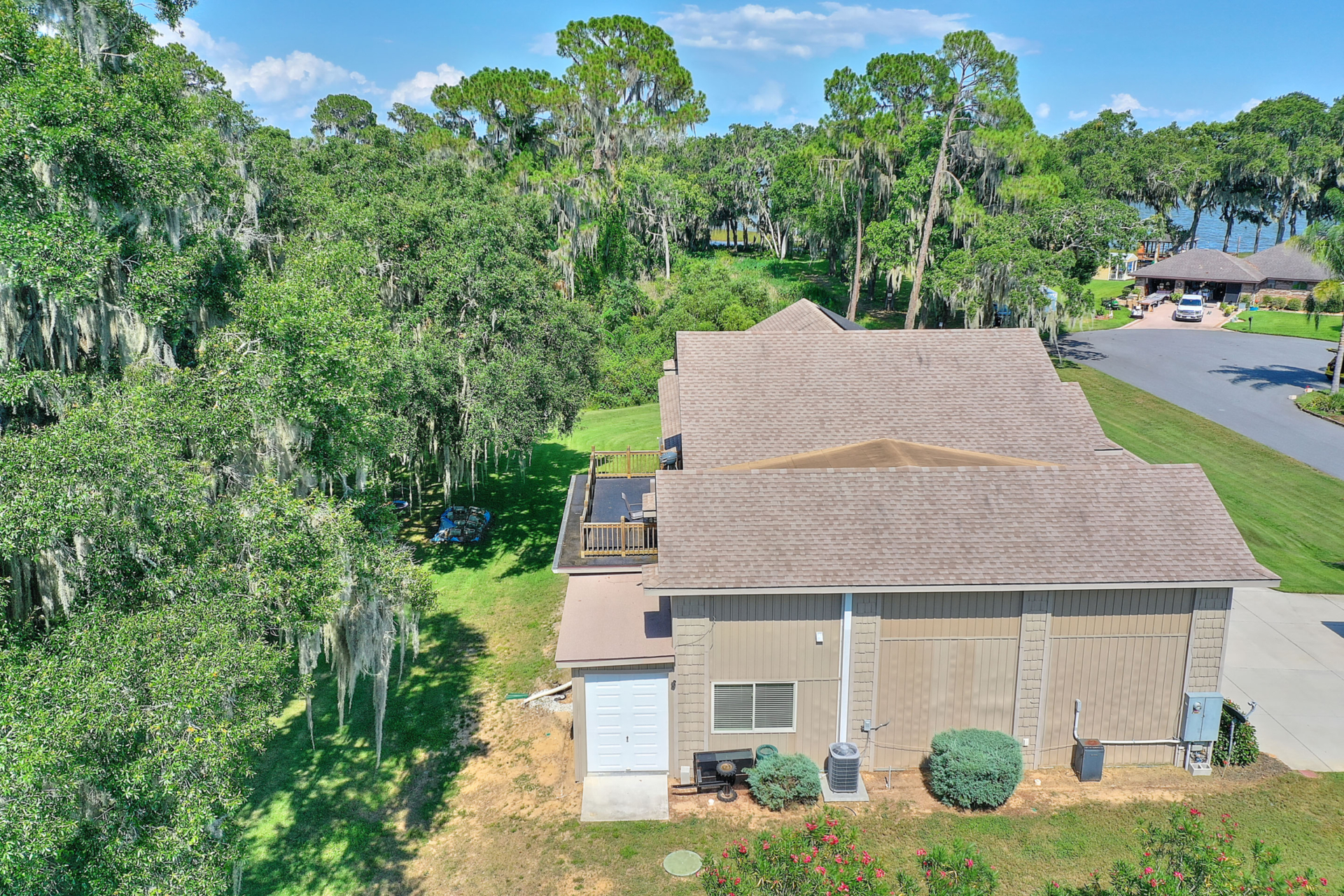 A house with trees in the background and a garage door open.