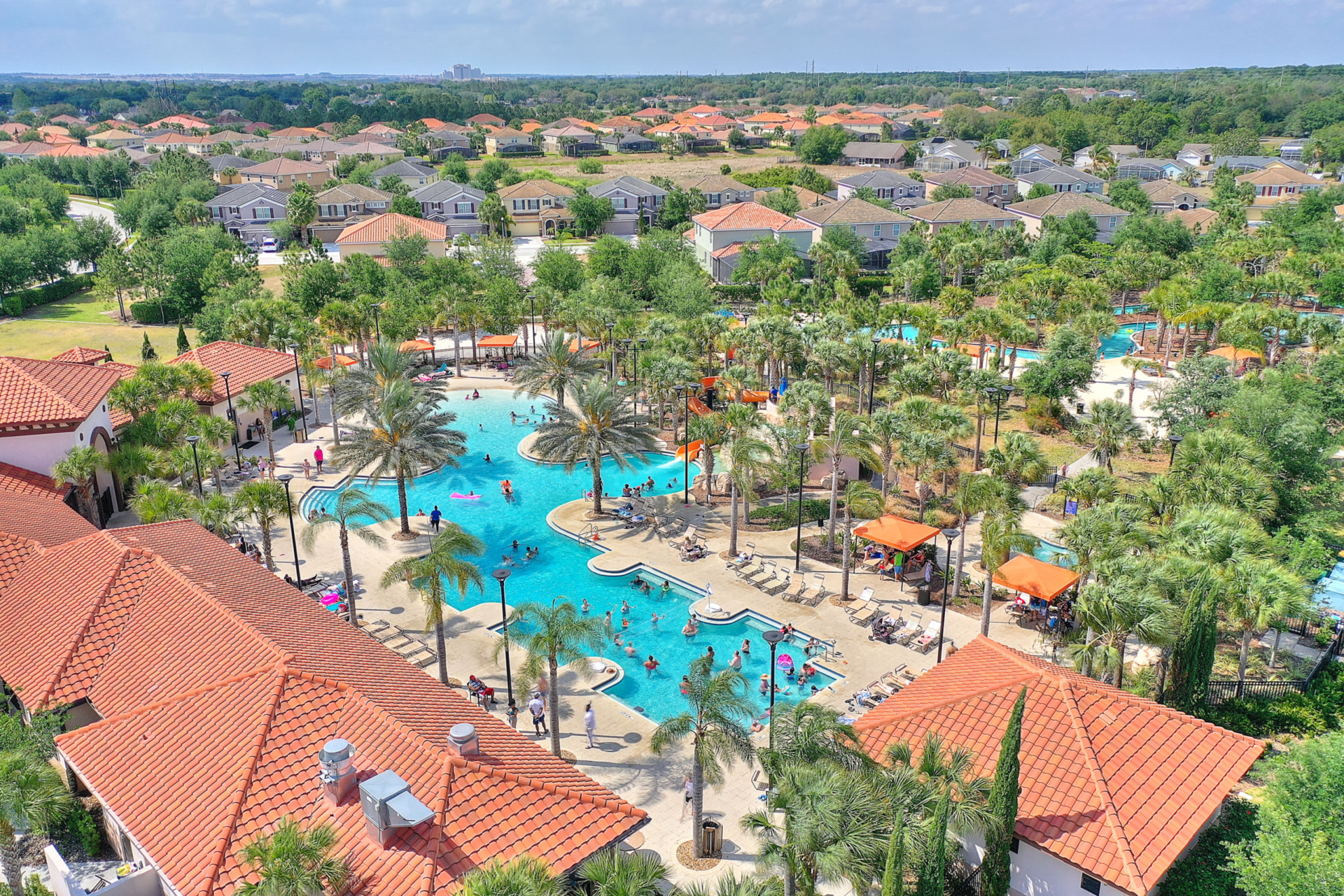 A resort pool with many swimming pools and palm trees.