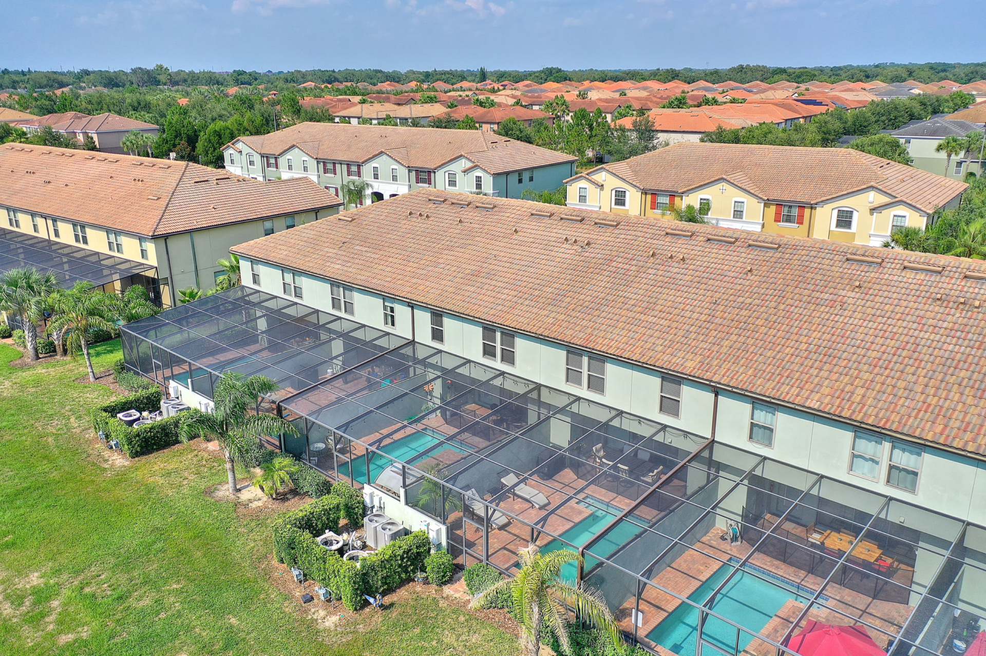 A group of houses with pools in the middle.