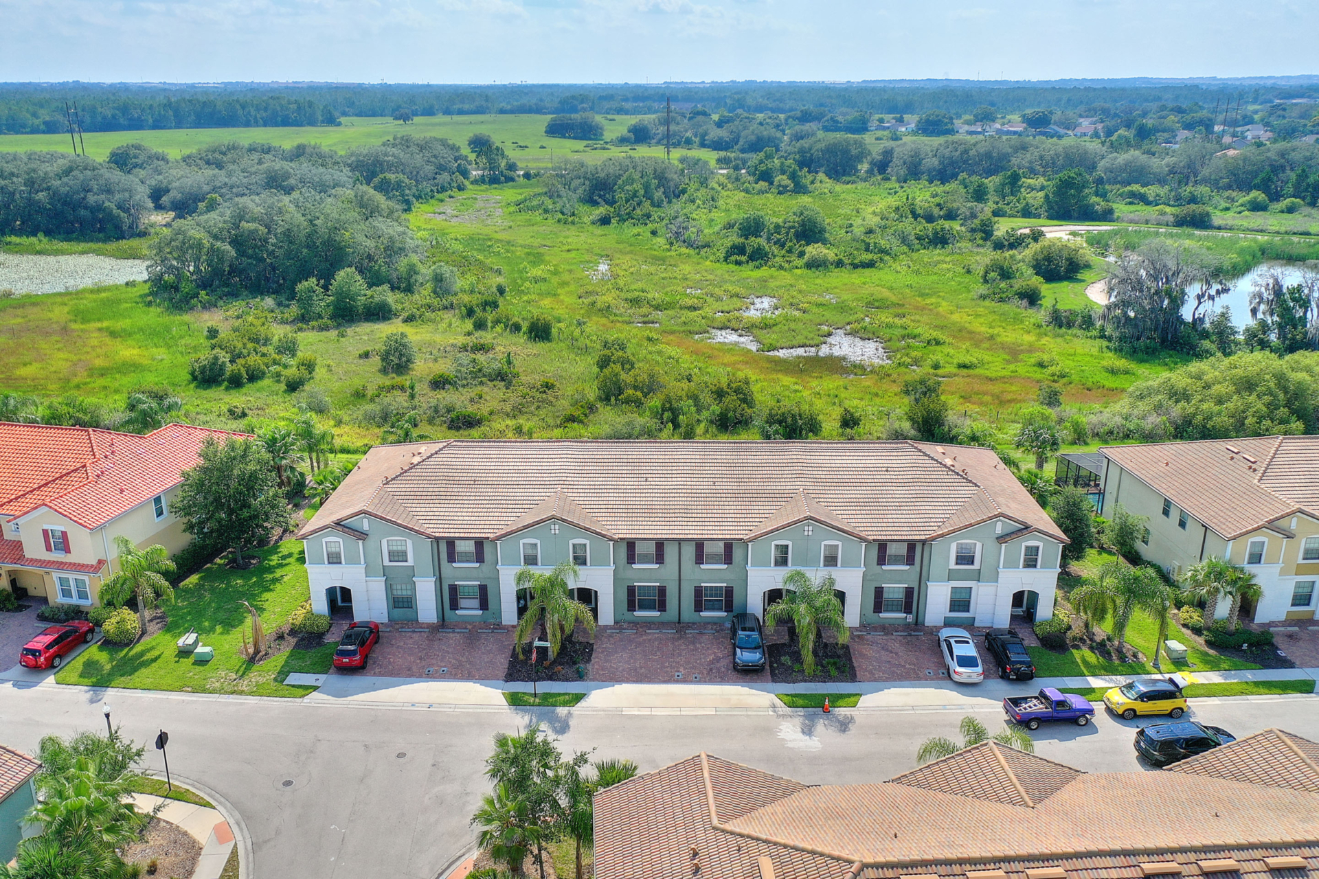 A aerial view of a building with cars parked in front.