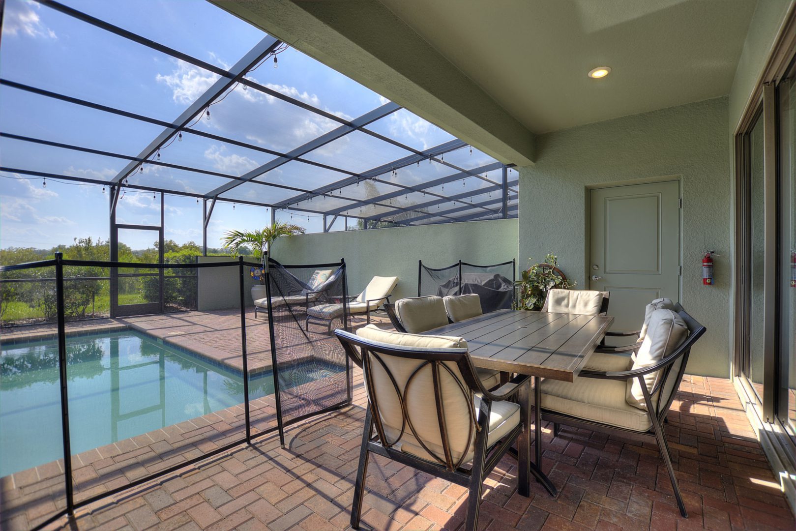 A patio with table and chairs next to the pool.