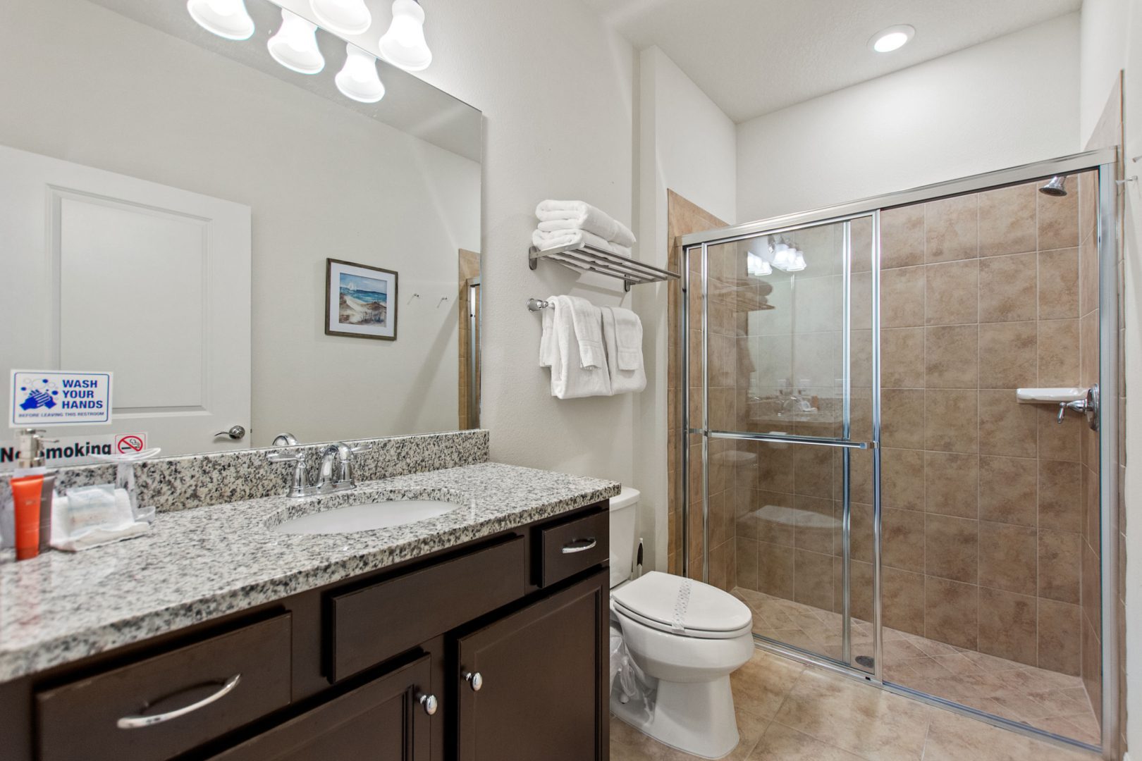 A bathroom with a shower, toilet and sink.