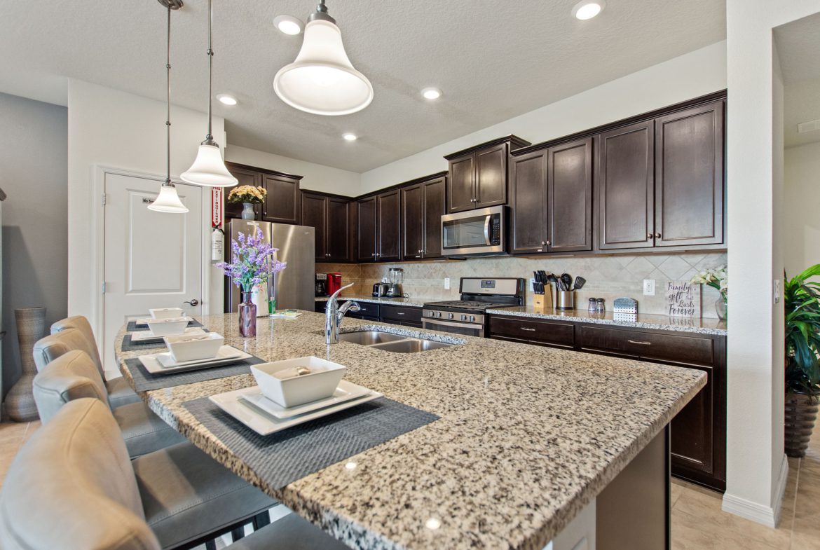 A kitchen with brown cabinets and granite counter tops.