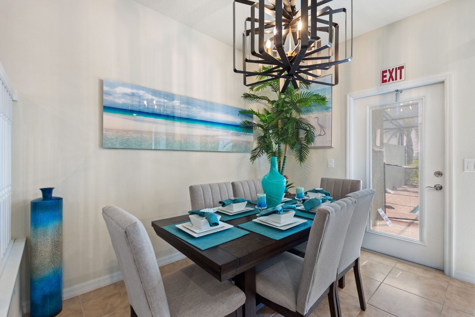 A dining room table with chairs and a painting on the wall.