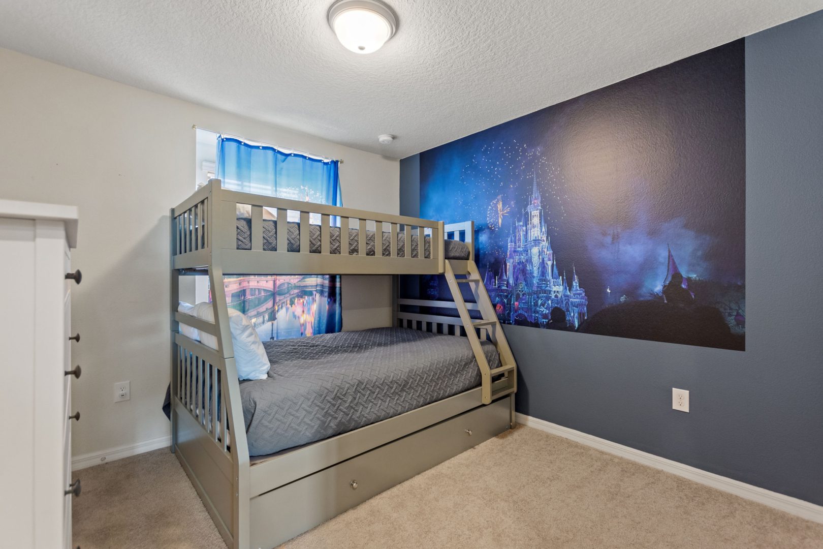 A bedroom with a bunk bed and a large mural.