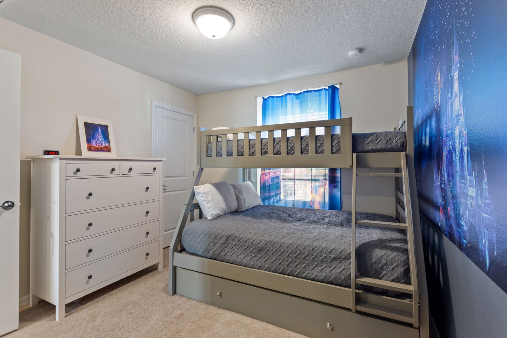 A bedroom with two bunk beds and a dresser.