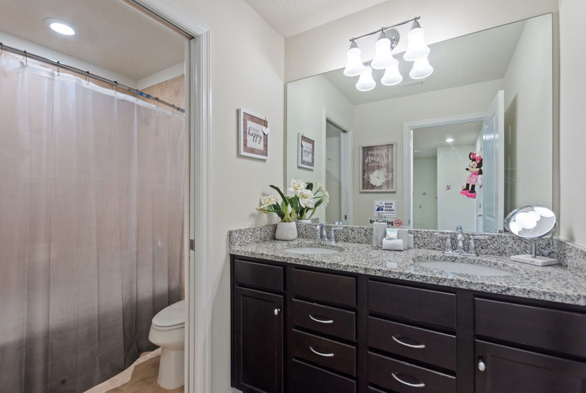 A bathroom with two sinks and a large mirror.