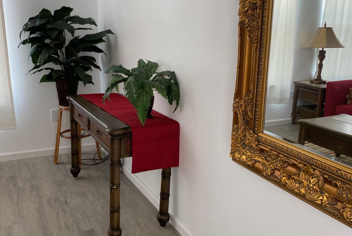 A table with plants and a mirror in the background