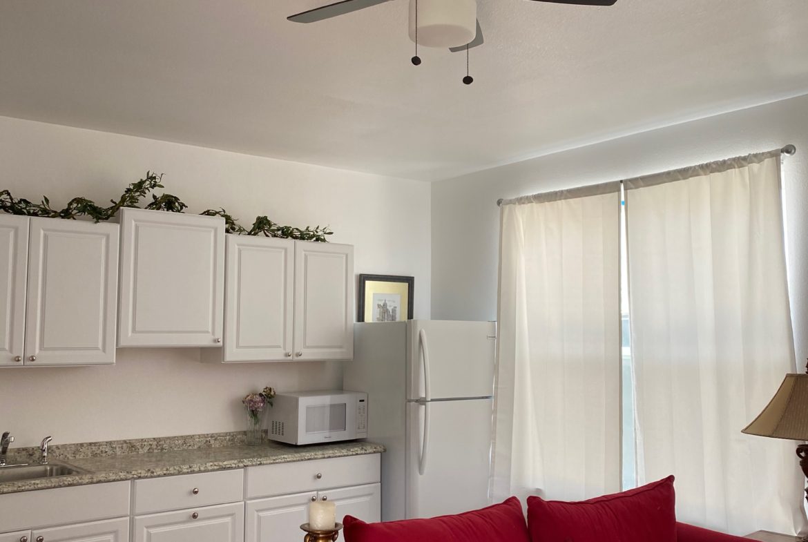 A living room with white cabinets and red couch.