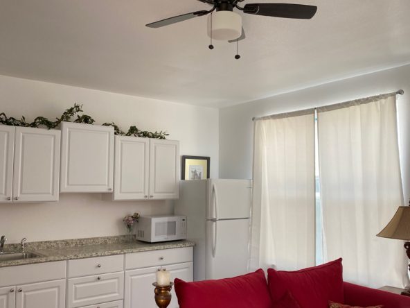 A living room with white cabinets and red couch.