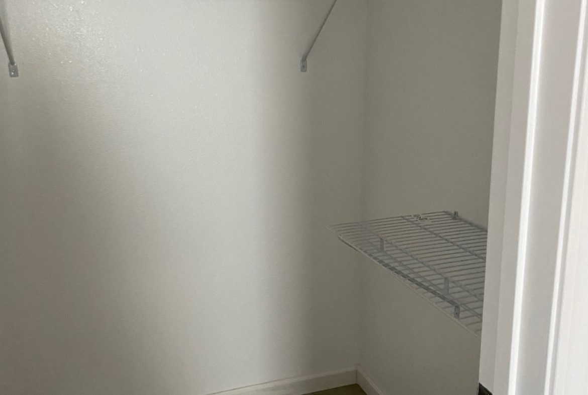 A closet with two shelves and a shelf for clothes.