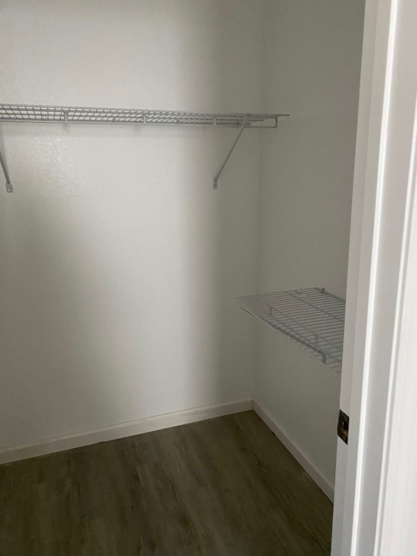 A closet with two shelves and a shelf for clothes.