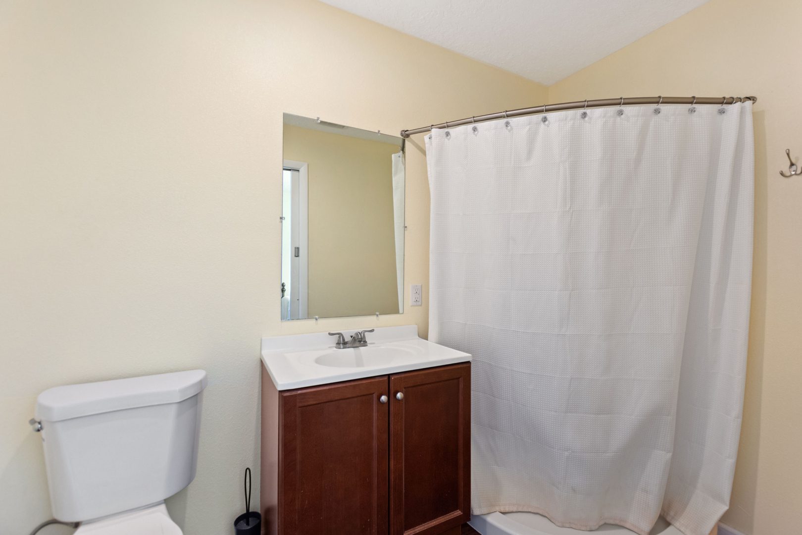 A bathroom with a sink, toilet and mirror.