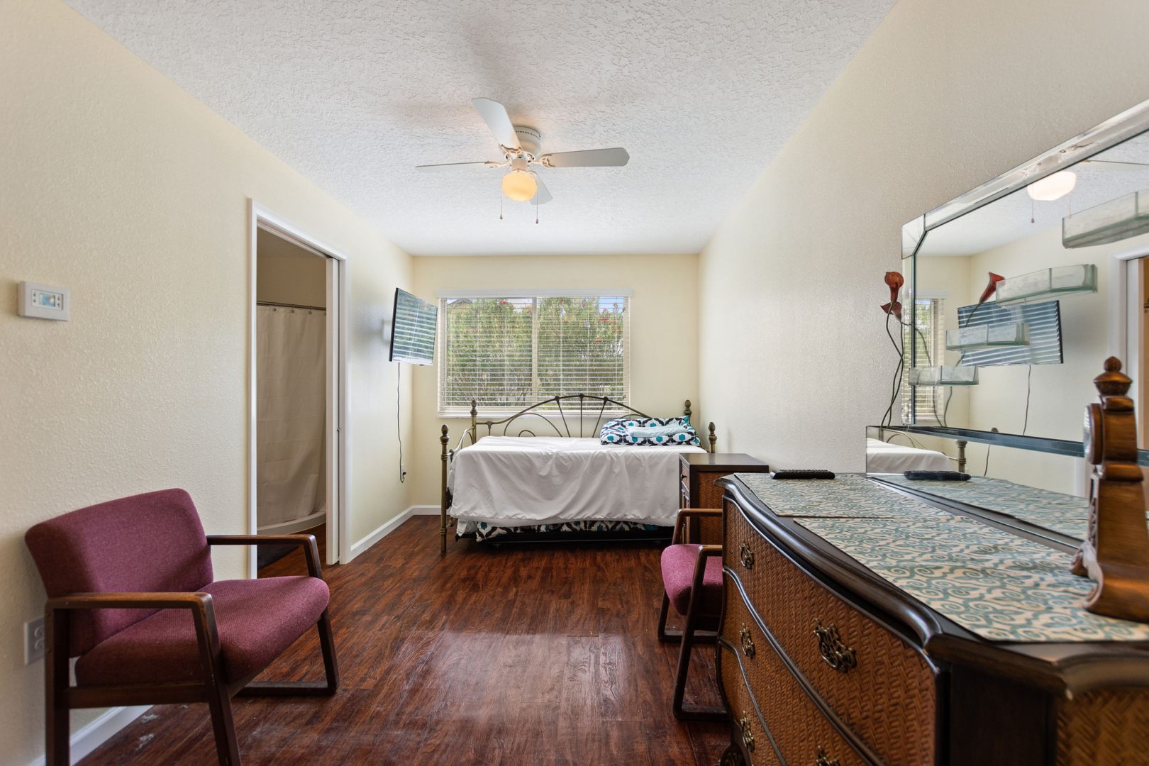 A bedroom with hard wood floors and furniture.