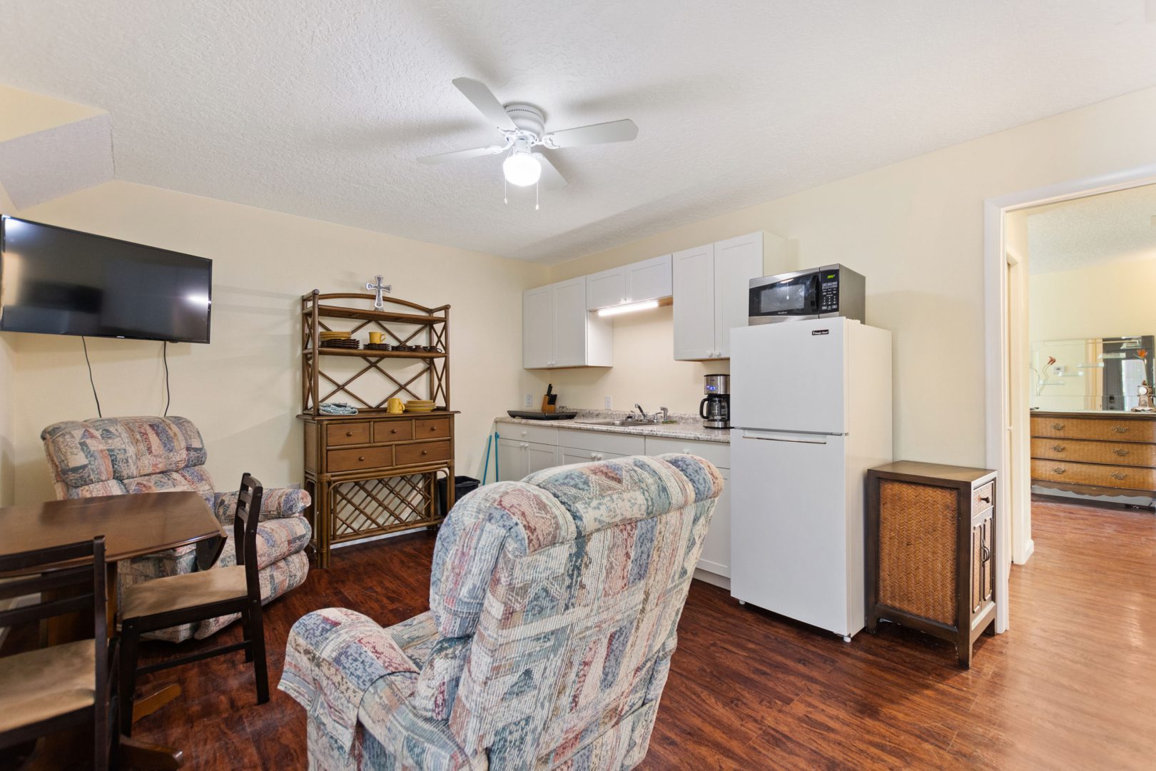 A living room with a couch, chair and microwave.