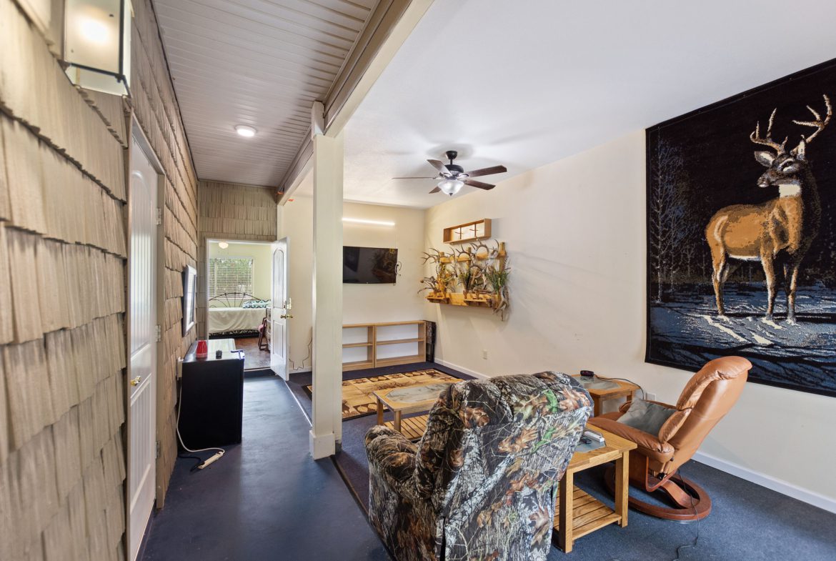 A living room with a couch, chair and television.