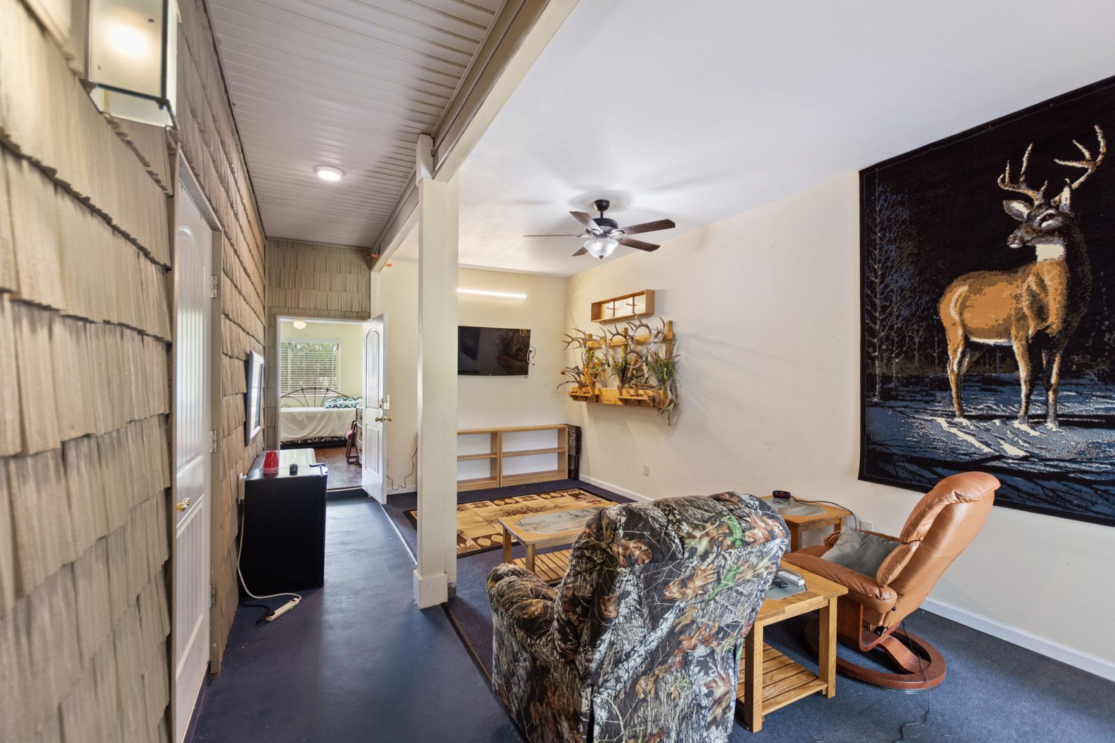 A living room with a couch, chair and television.