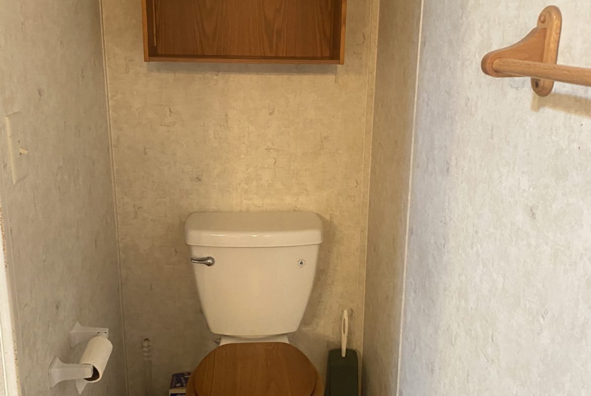 A white toilet in a small bathroom.