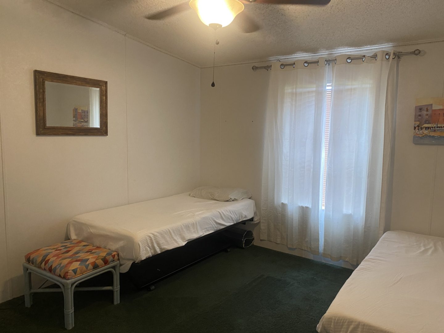 Two beds in a bedroom with a window.