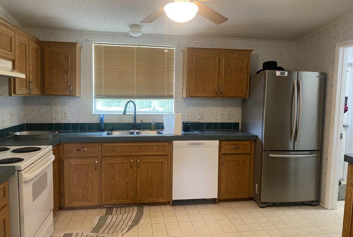 Kitchen with wood cabinets and a stainless steel fridge.