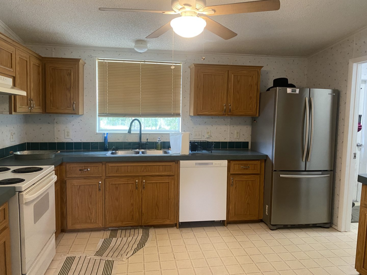 Kitchen with wood cabinets and a stainless steel fridge.