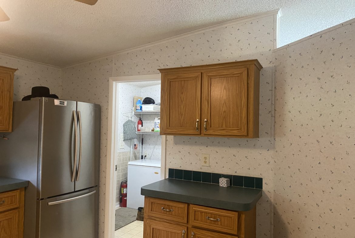 Kitchen with stainless steel refrigerator and cabinets.