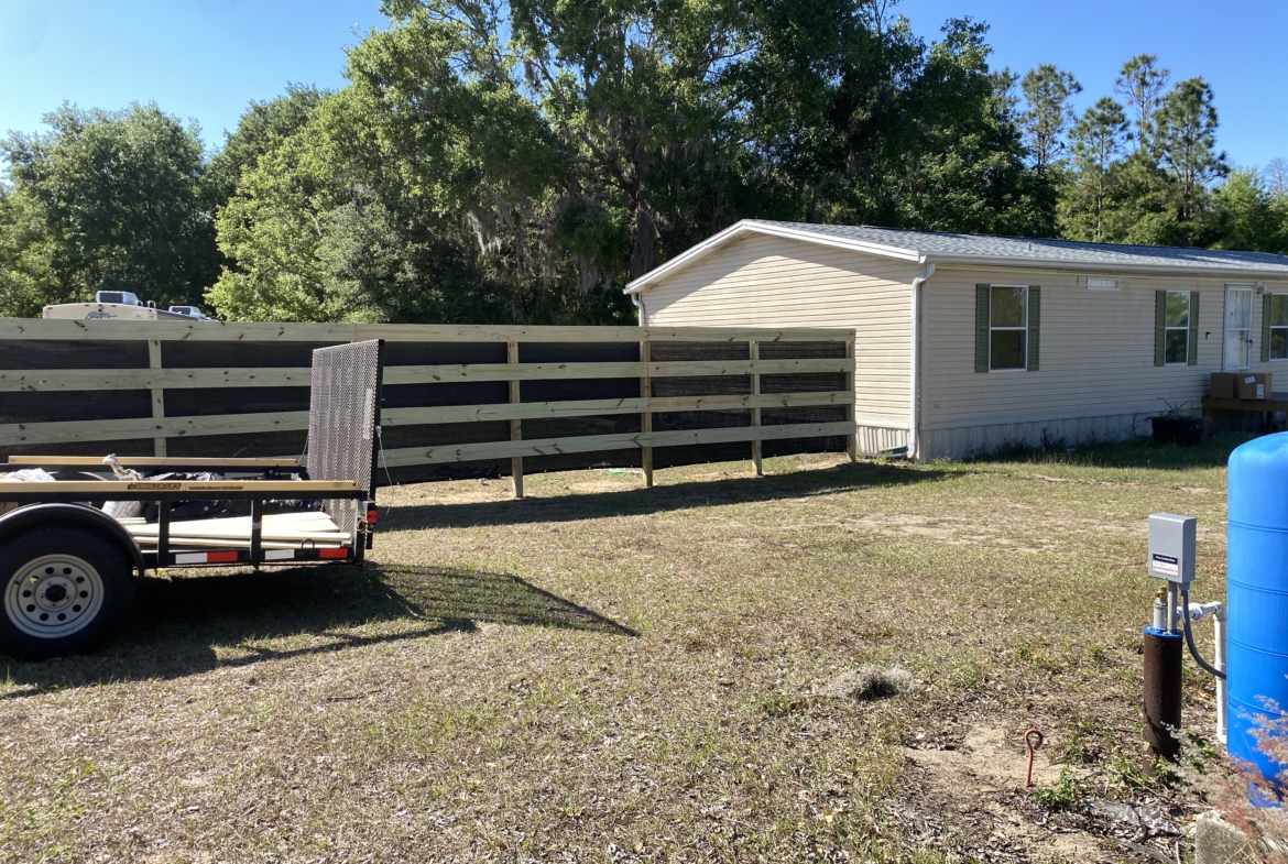 A mobile home with a wooden fence.