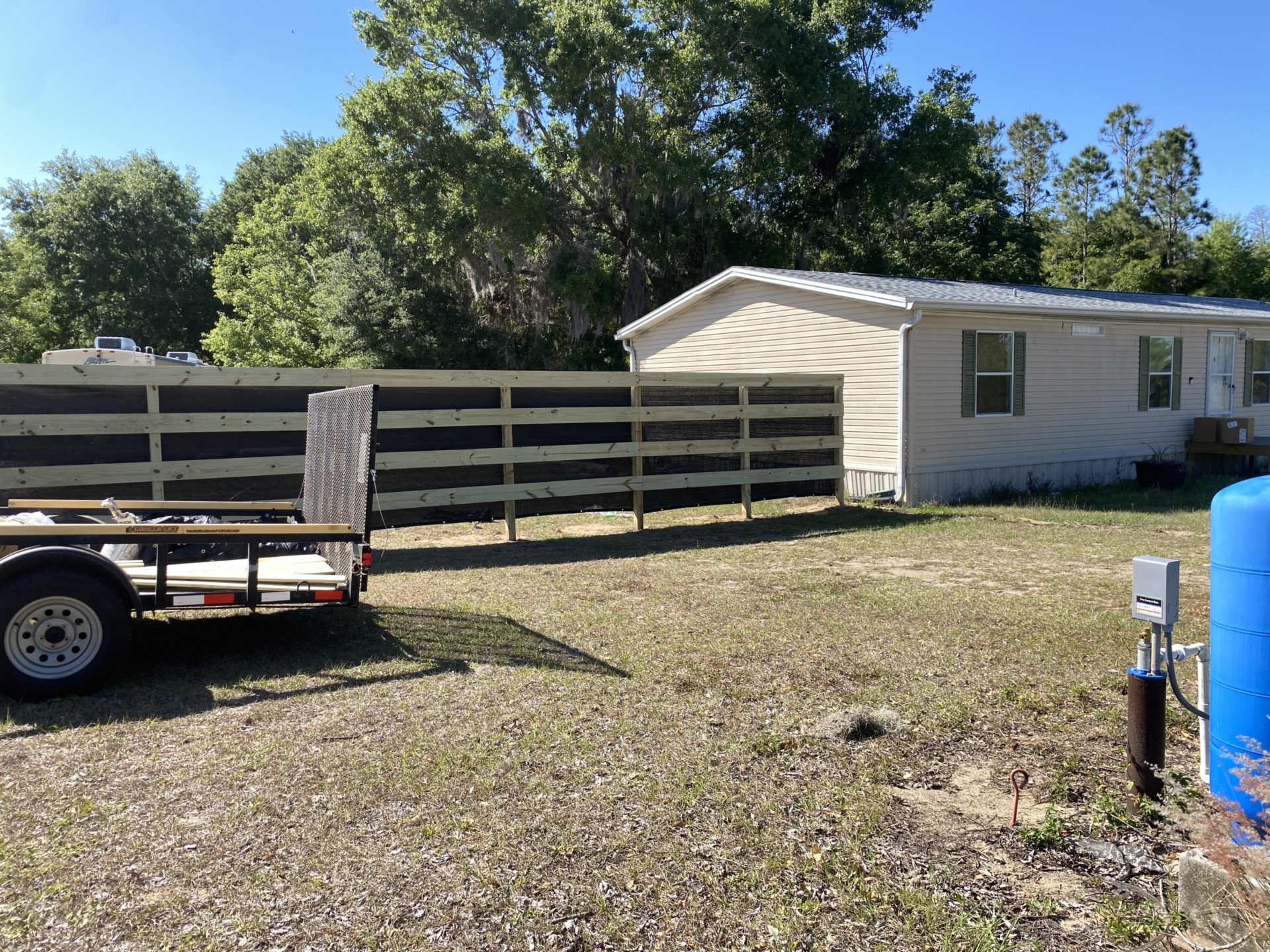 A mobile home with a wooden fence.